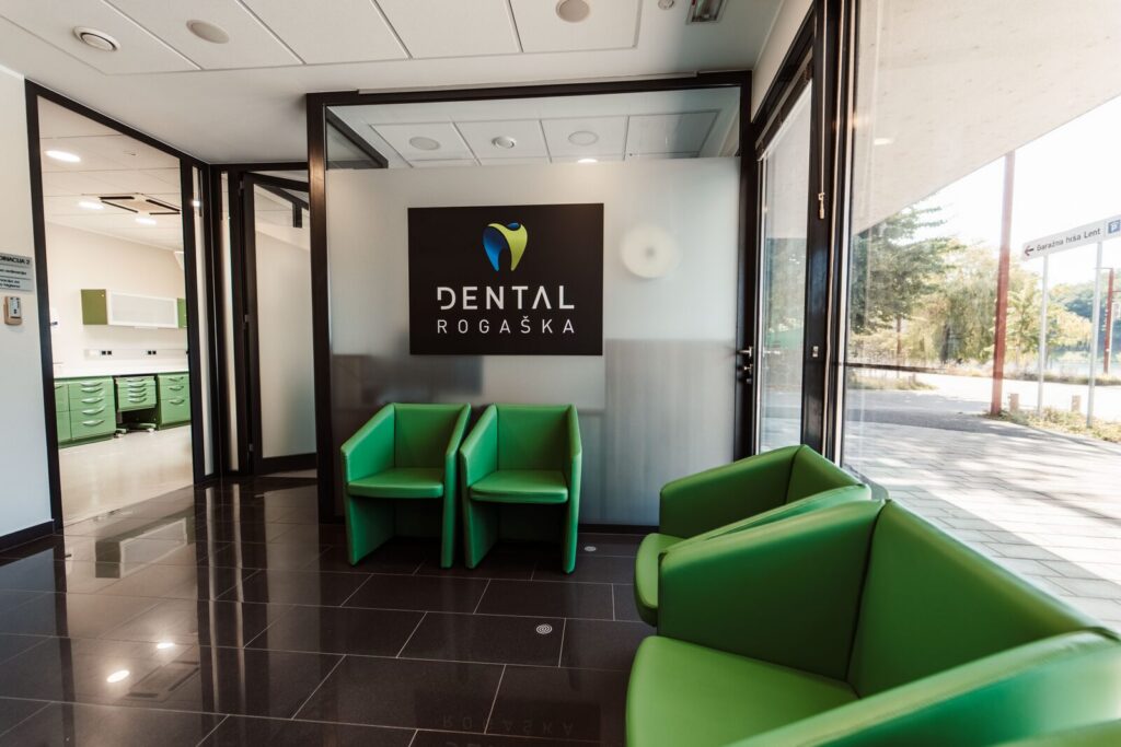 Čakalnica z zelenimi fotelji in logotipom Dental Rogaška v Mariboru