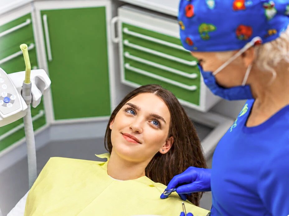 Zobozdravnica Dental Rogaška pregleduje zobe nasmejane pacientke na zobozdravniškem stolu
